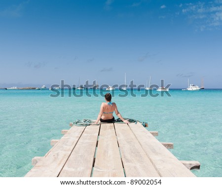 Woman watching the sea sitting on a jetty