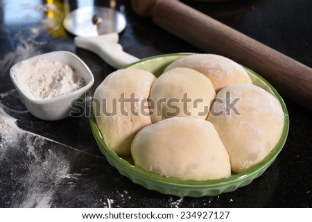 Balls of pizza dough on a wooden board.