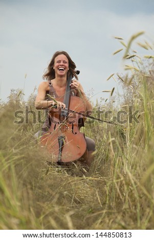 Lady playing cello in the corn