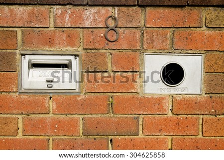A mailbox in a brick enclosure with an address / name plate for your use, pick up the newspaper, flyers, ads, use as background.