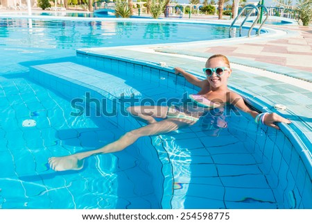 Young woman enjoying warm water in pool at tourist resort