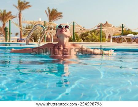 Young woman enjoying warm water in pool at tourist resort