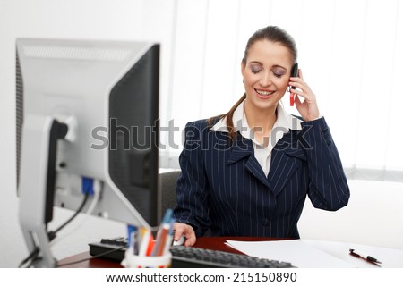 Brunette office worker sitting in office and calling, teeth smile