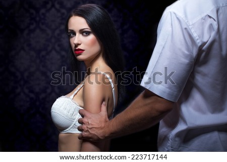 Strong man grabs woman arm at night, passionate couple