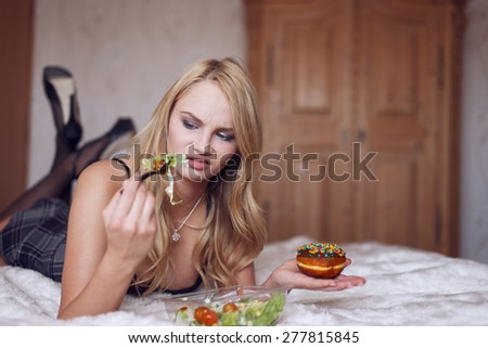 Blonde woman hates salad, laying on bed, diet
