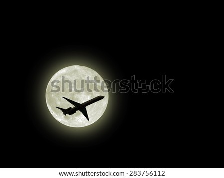 an airplane flying across a full moon