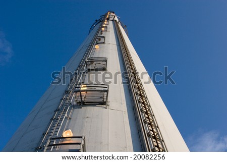 close view of a tall industrial chimney from the ground up, horizontal framing