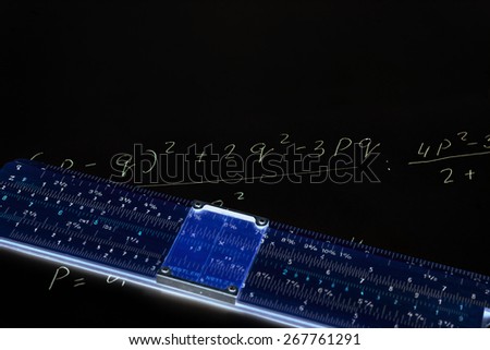Slide rule on a black background with neon lights and write the formula