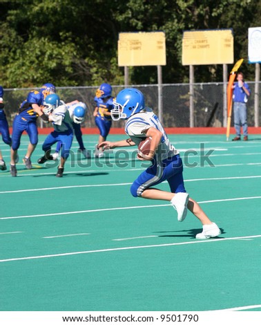 Youth Football Player Running with Ball for Touchdown