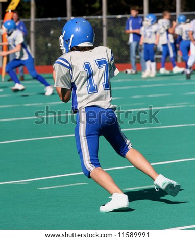Youth Teen Football Player after catching football