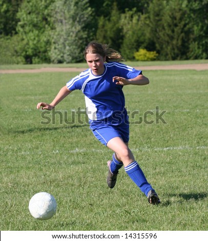 Youth Teen Girl Chasing Soccer Ball Down the Field