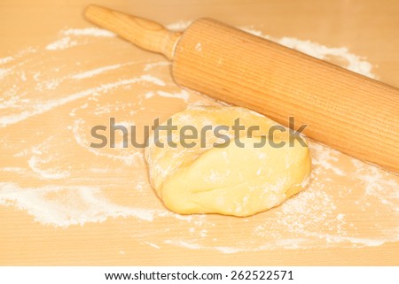 rolling pin, pastry and meal for baking a cake on the table
