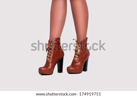 close-up of woman legs in black stockings wearing suede boots on high heel