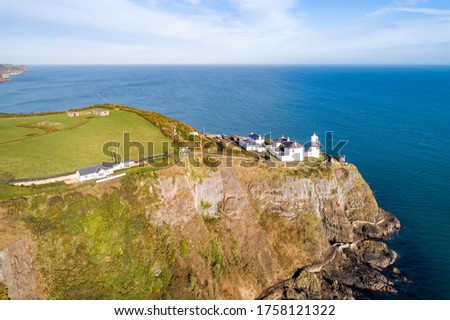 Blackhead Lighthouse and coastal path near Carrickfergus and Belfast on a steep cliff on the Atlantic coast at the entrance to the Belfast Laugh in County Antrim, Northern Ireland, UK. Aerial view