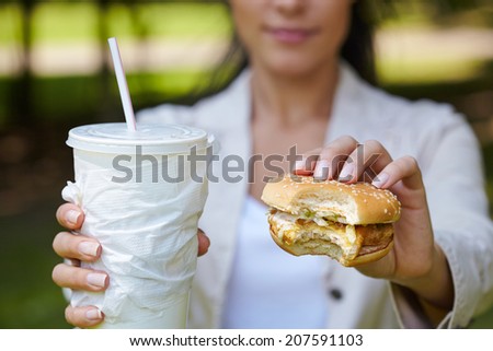 woman eating hamburger and cocktail