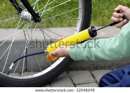 Boy pumping bicycle tyre, close-up on hands
