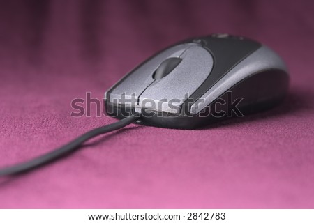 computer mouse of grey color on purple velvet background