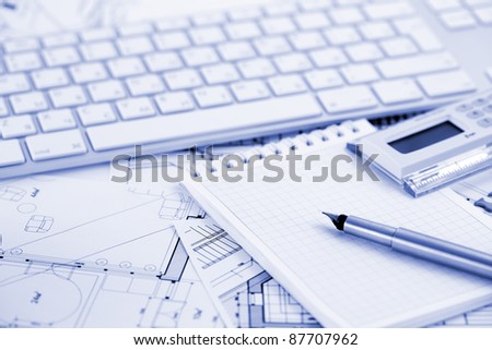 computer keyboard, calculator, notepad, ink pen and architectural drawings of the modern house