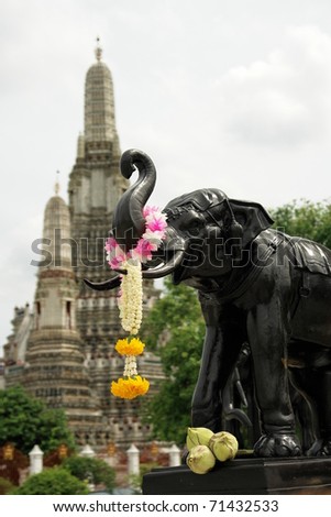 An elephant raised a colorful floral loop in a corner of a Thailand style temple in Thailand