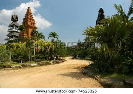 Landscape with the tropical forest and curling road of earth in jungles going to the temple.