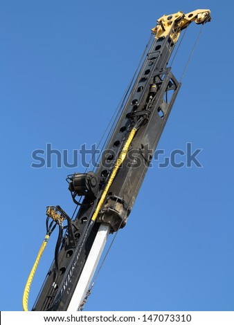 Pile-driver in action against the blue sky.