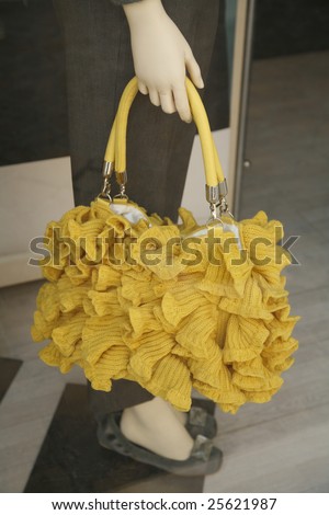 Knitted bag seen through a shop window - Umbria, Italy.