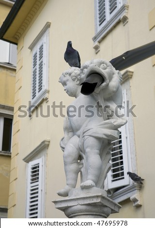 Architecture detail - Piran, Istria, Slovenia. Attention: New use of an ancient statue - base for as drainpipe!