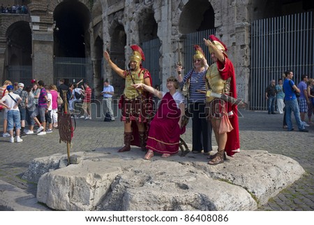 ROME, ITALY - SEPTEMBER 27: Unidentified street performers dressed like Roman soldiers offer photo sessions to unidentified tourists in front of Colosseum in Rome, Italy on September 27, 2011.