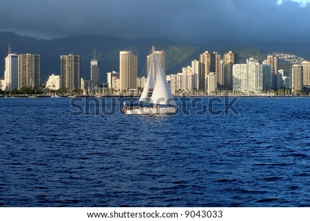 Boat sailing along Honolulu skyscrapers in Hawaii