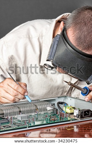 Engineer repairing circuit board, in computer equipment. coarse style picture