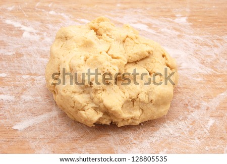 Fresh ball of pastry ready to be rolled out on a floured wooden board
