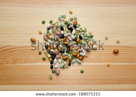 Mixed dried beans - black turtle beans, flageolet beans, pinto beans, brown beans, haricot beans, green split peas and yellow split peas - on a wooden background