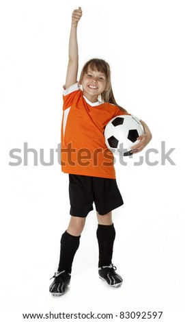 Full length studio photo of cute female child standing holding a soccer ball.