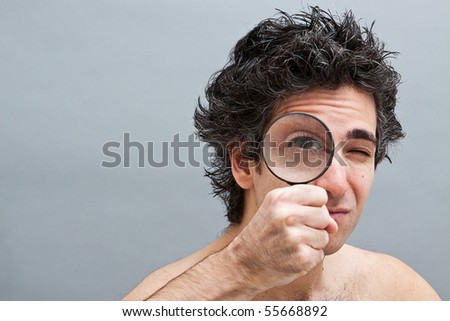 Curious man holding a magnifier over his eye