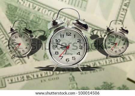 Time is money. Alarm clock on money background