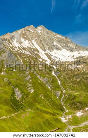 Mountain landscape with meadows and snow-capped summit