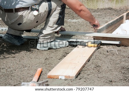 Mason preparing formwork in wood to build a terrace