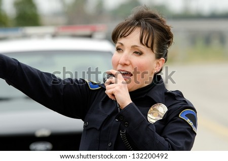 a policewman talking on her police radio to other officers.