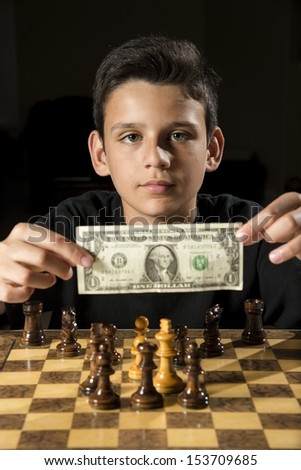 a boy shows money as he tries to bet on a chess game.