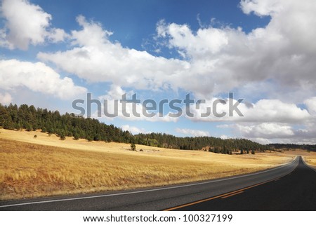 Road to the Grand Canyon. Autumn yellow fields and the magnificent cloudy sky