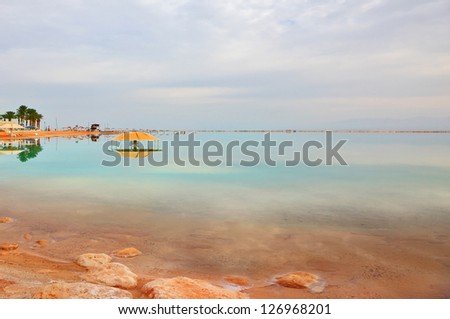 Winter in the Dead Sea. The comfortable high-rise hotel  is reflected in the sea smooth water