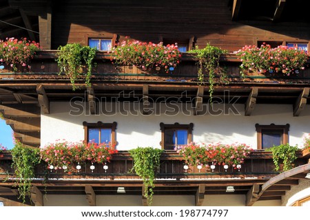 Guest house in Austria. Front of the house is traditionally decorated with pots of geraniums