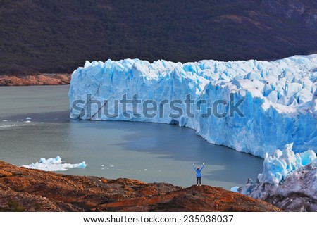 The woman - tourist admire the white-blue icy splendor. Giant lake Perito Moreno glacier
