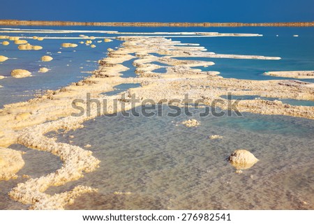 The picturesque road from the evaporated salt in the Dead Sea. Salt formed long paths with scalloped edges. Israel in October