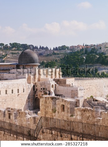 Gray dome of the Al-Aqsa Mosque on the Temple Mount in Jerusalem. The ancient walls of Jerusalem, lit morning sun.