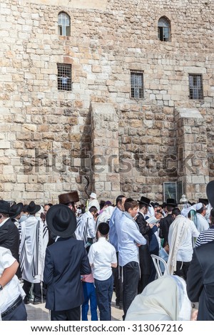 JERUSALEM, ISRAEL - OCTOBER 12, 2014: Crowd of faithful Jews wearing prayer shawls. Morning autumn Sukkot. The area in front of Western Wall of  Temple filled with people