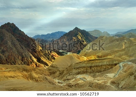 Road between multi-coloured mountains in desert near to the city of Eilat in Israel