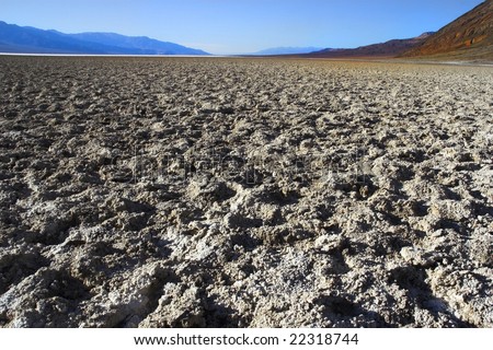 A dry waterless clay surface and mountains in the distance