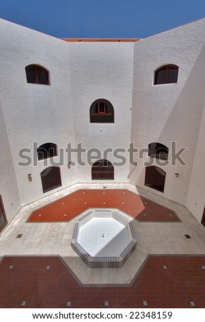An internal court yard in the Spanish style - a patio and a bowl of a fountain