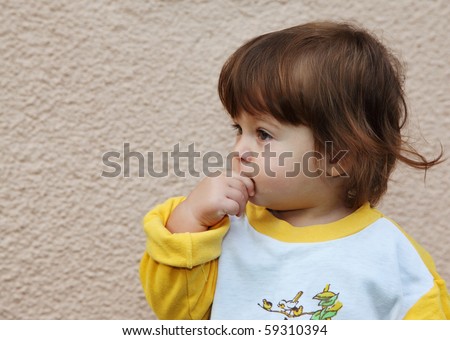 The charming little boy thoughtfully looks afar